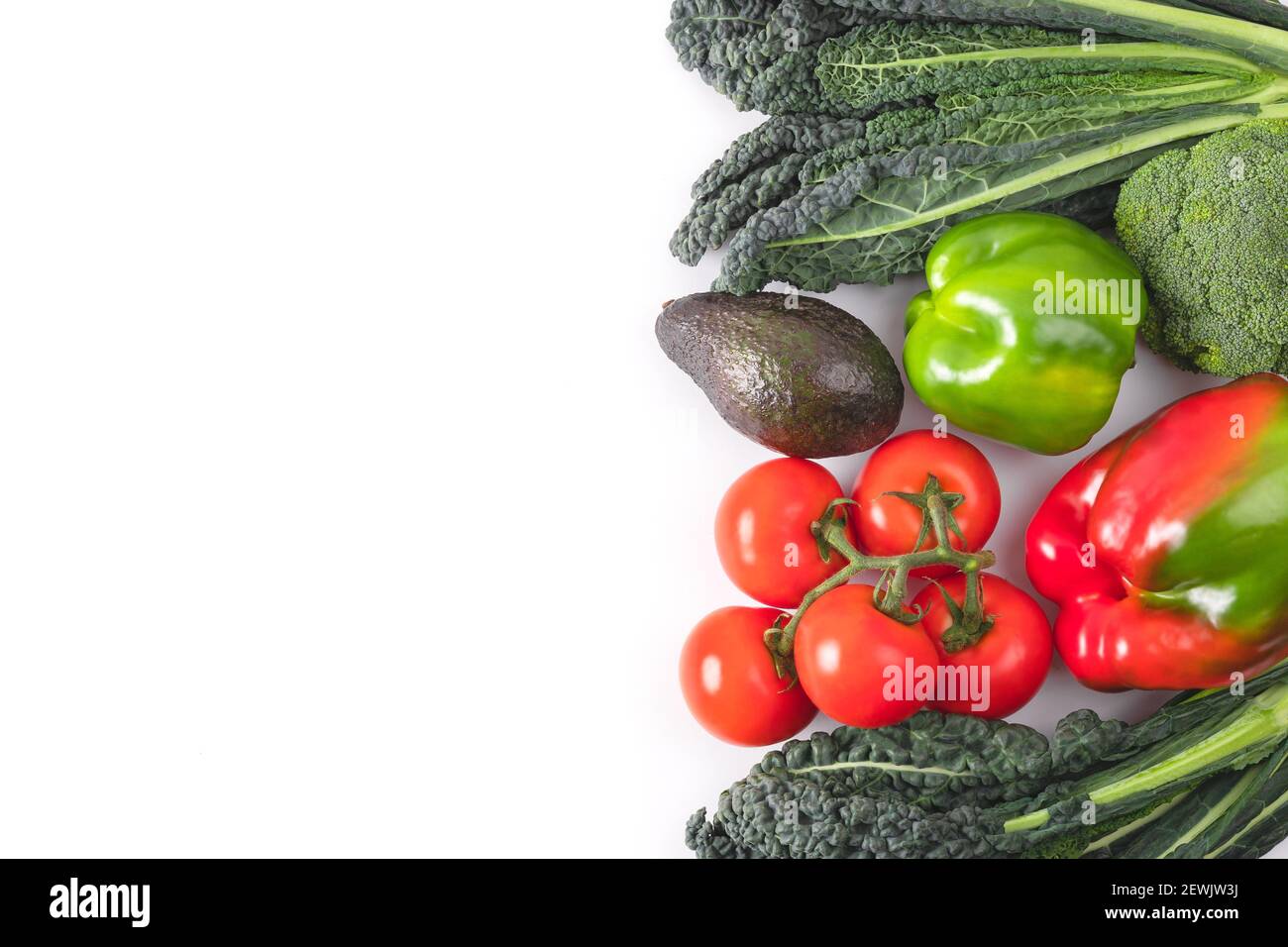 Cadre de légumes frais. Feuilles de chou noir, branche de tomates, poivron rouge et vert, avocat. Une délicieuse maquette de légumes crus. Concept de Banque D'Images