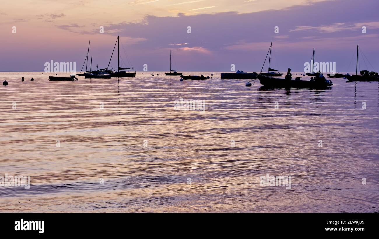 Lever de soleil sur l'océan avec silhouettes de bateaux sur l'île de Noirmoutier, France. Ciel spectaculaire le matin. Banque D'Images