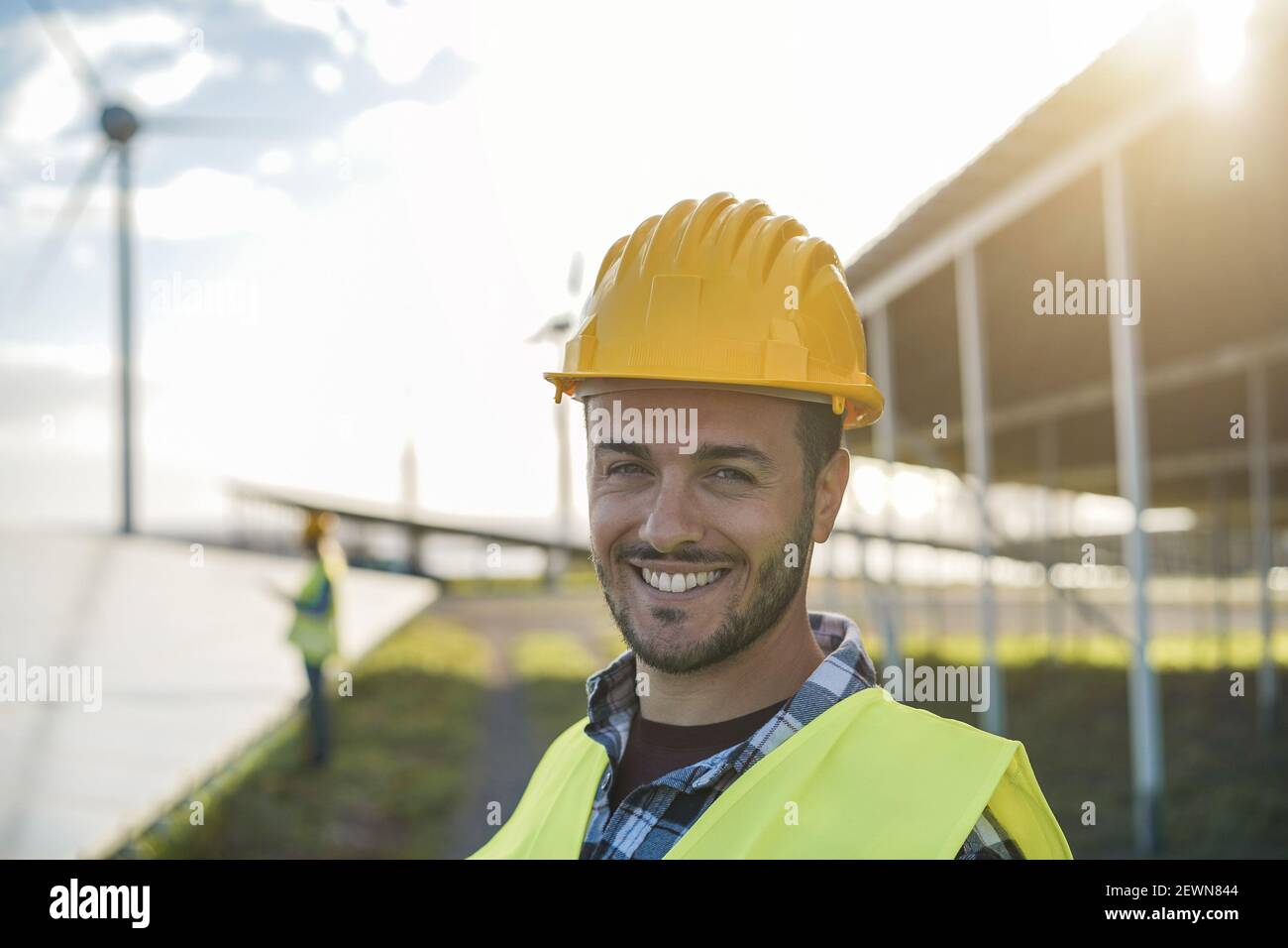 Jeune homme travaillant dans une ferme d'énergie renouvelable - Eco et Concept d'environnement - accent sur le visage Banque D'Images