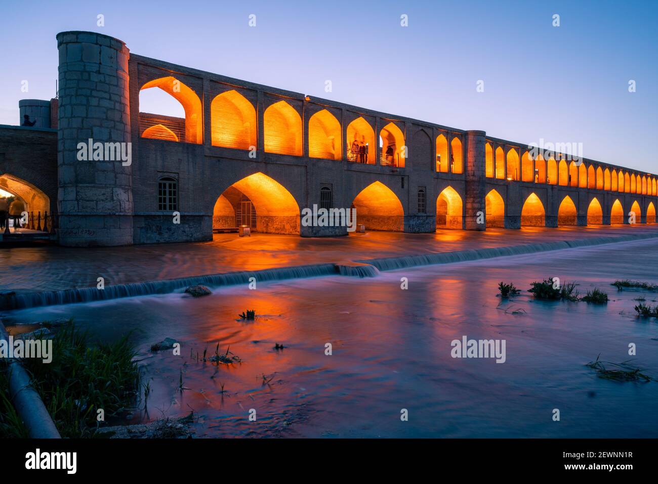 Ispahan, Iran - 14.04.2019 : chute de nuit au pont si O se Pol, Ispahan, Iran. Les lumières orange sur le pont contrastent avec le ciel bleu qui s'estompe. Banque D'Images