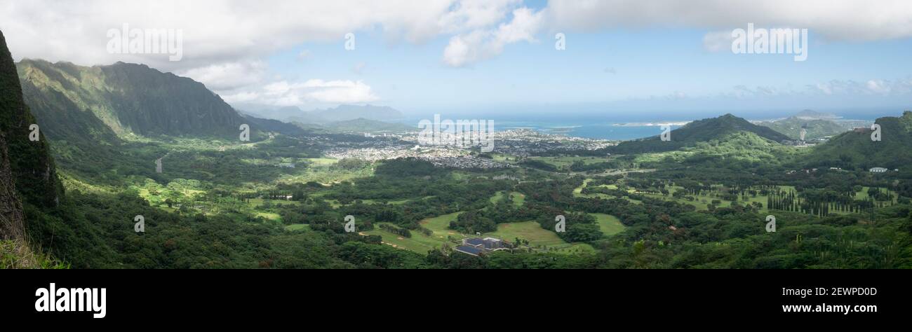 Vue panoramique sur la vallée tropicale verte avec quelques nuages et l'océan en arrière-plan, tourné au point de vue de nu´uanu Pali à Oahu, Hawaii, États-Unis Banque D'Images