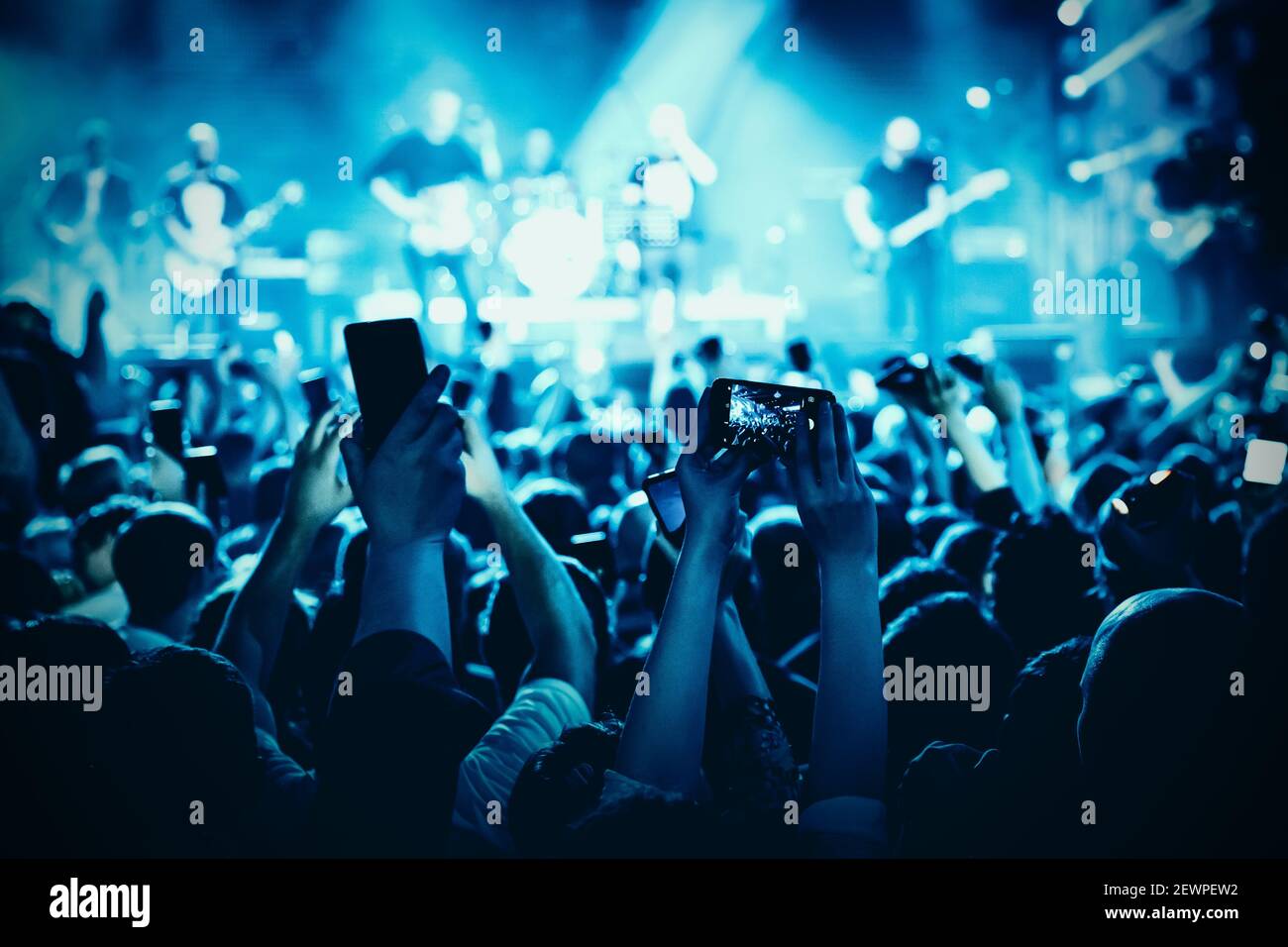 Main avec le smartphone allumé pour enregistrer ou prendre des photos  pendant le concert en direct Photo Stock - Alamy