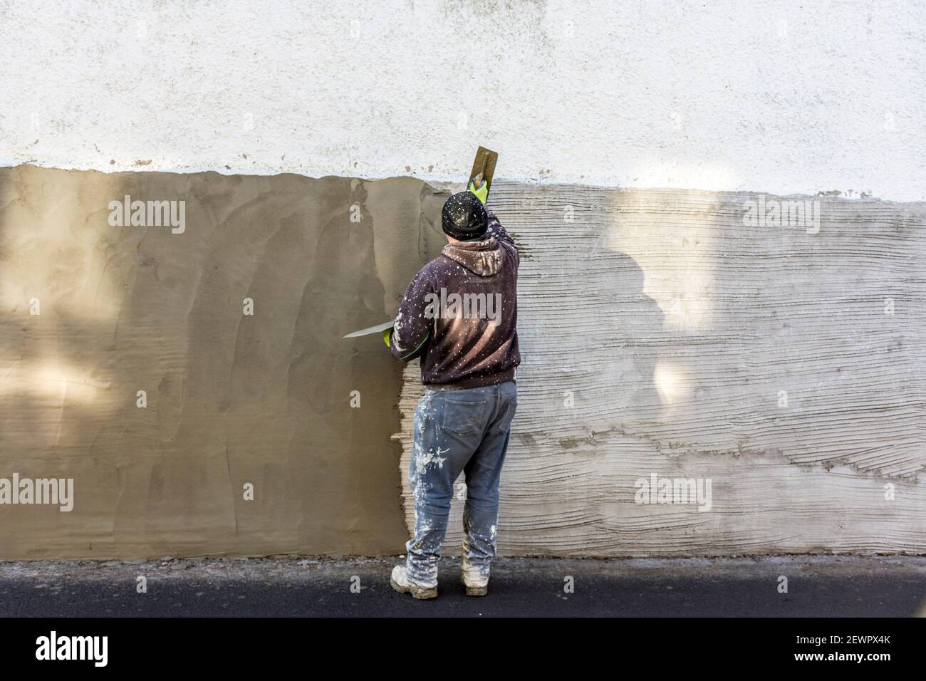 Homme réparant un mur. Banque D'Images