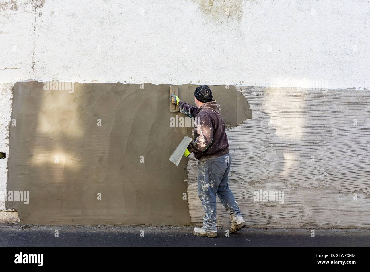 Homme réparant un mur. Banque D'Images