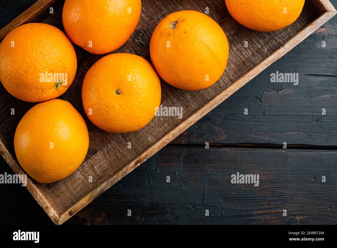 RAW Organic Cara Navel oranges set, dans boîte en bois, sur l'arrière-plan de table en bois foncé, vue de dessus plat lay , avec copyspace et espace pour le texte Banque D'Images