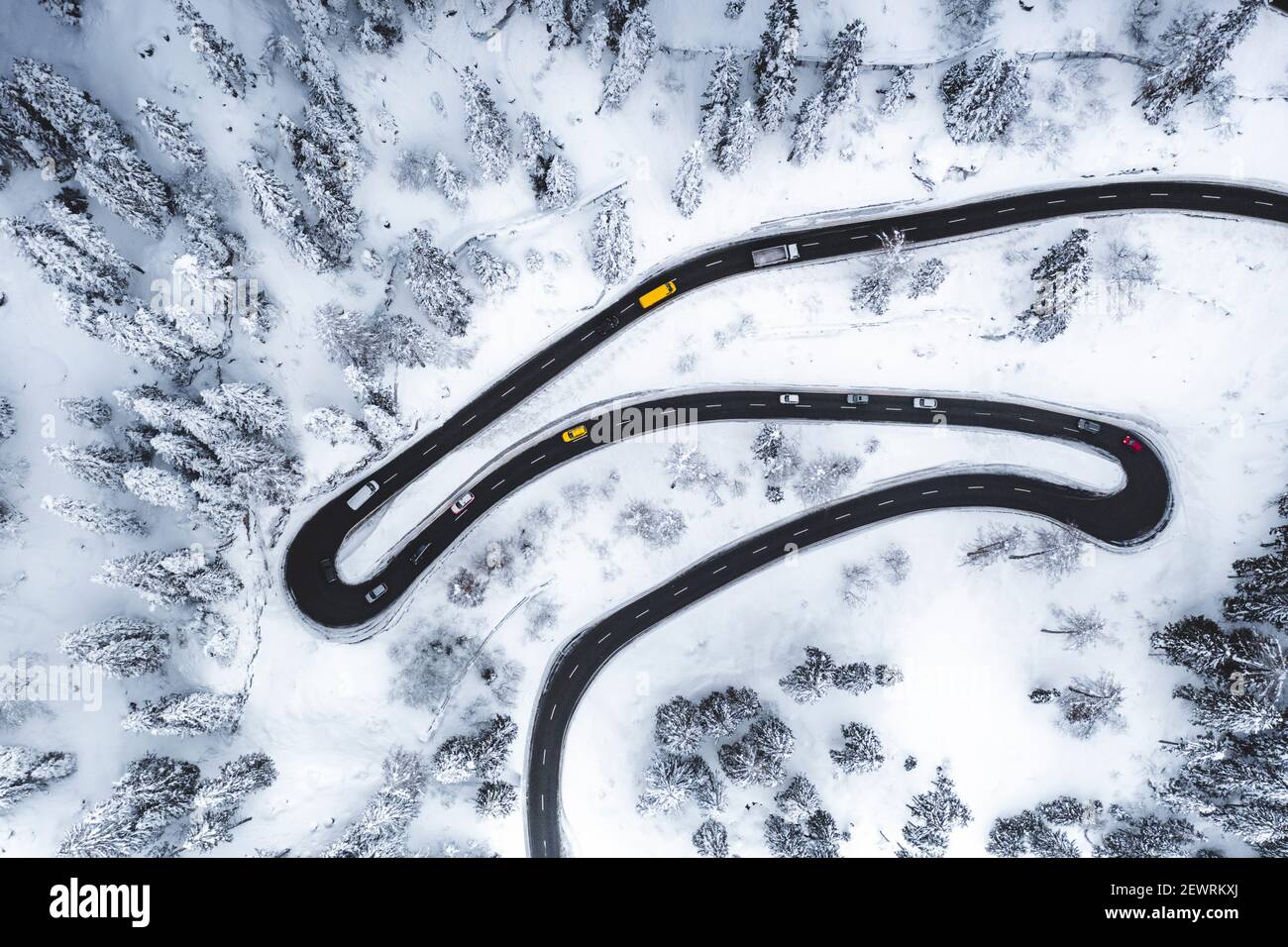 Vue aérienne des voitures roulant sur des virages étroits de route de montagne dans la neige, Suisse, Europe Banque D'Images