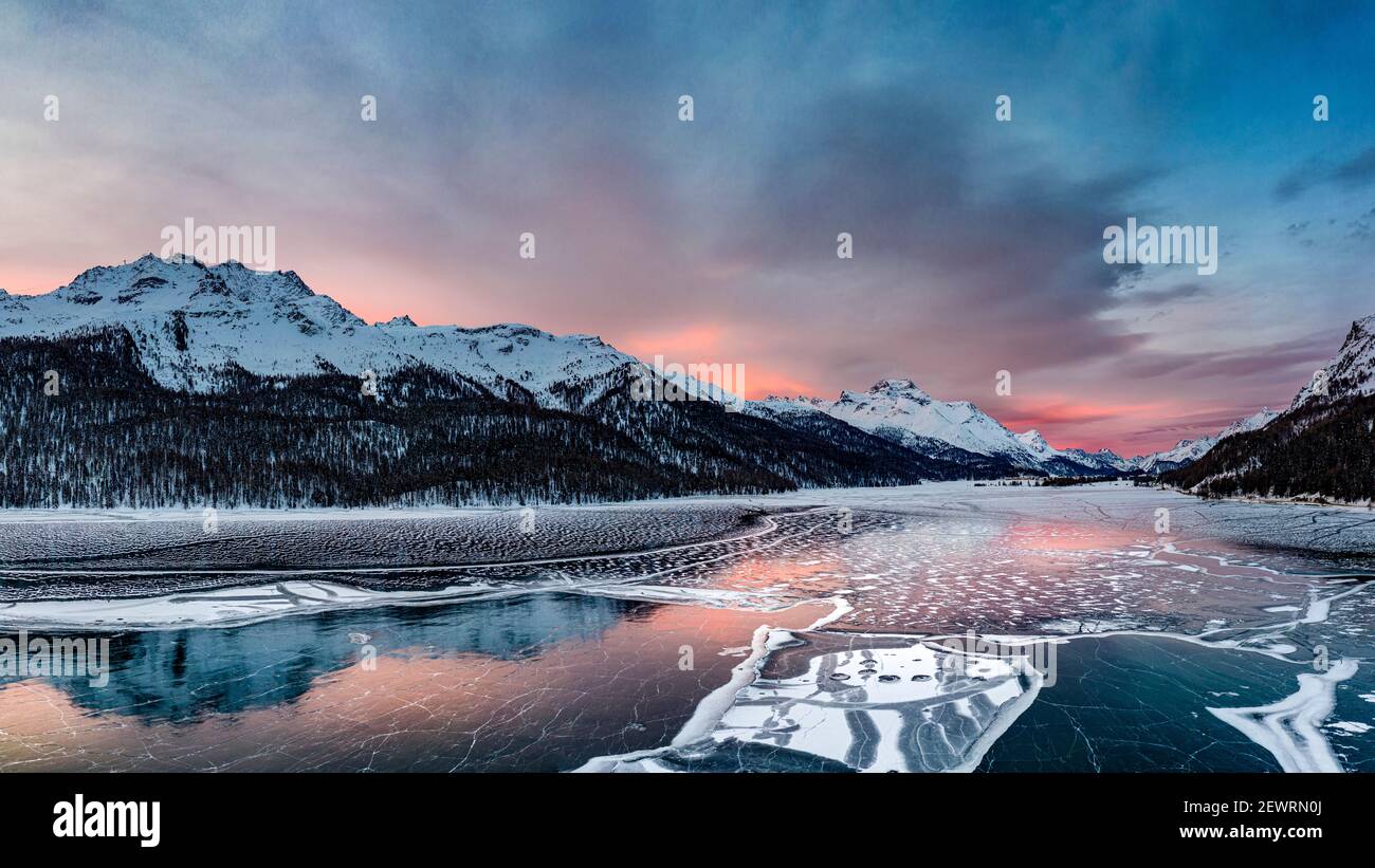 Vue aérienne des montagnes enneigées et du lac gelé Silvaplana au lever du soleil, Maloja, Engadine, canton de Graubunden, Suisse, Europe Banque D'Images