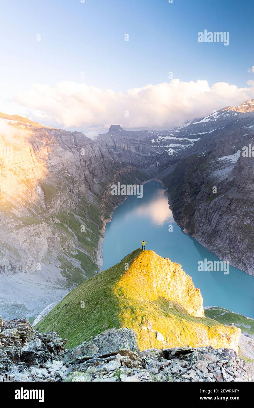 Vue aérienne de l'homme gai avec des bras étendus en admirant le lac Limmernsee au coucher du soleil, canton de Glaris, Suisse, Europe Banque D'Images