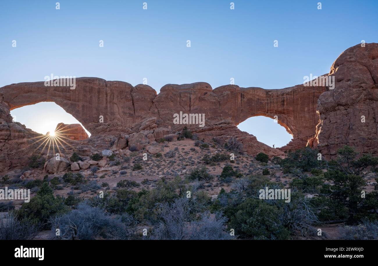 Sunburst et randonneur à Windows Arches, Parc national d'Arches, Utah, États-Unis d'Amérique, Amérique du Nord Banque D'Images