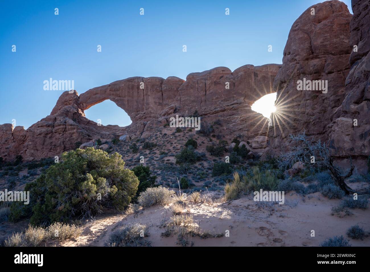 Sunburst à travers Windows Arch, Parc national d'Arches, Utah, États-Unis d'Amérique, Amérique du Nord Banque D'Images