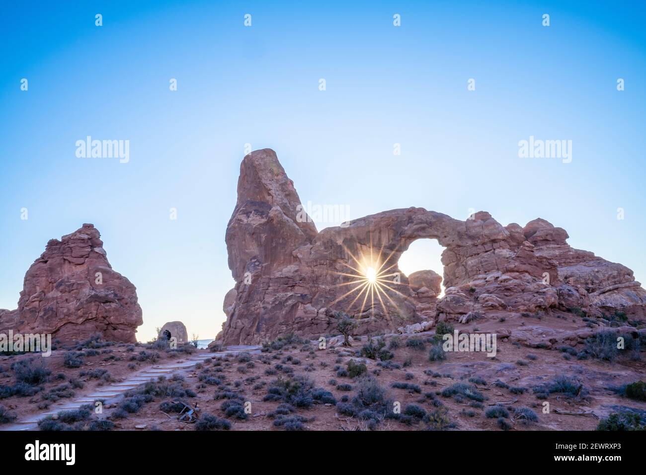 Sunburst à travers Turret Arch, parc national d'Arches, Utah, États-Unis d'Amérique, Amérique du Nord Banque D'Images
