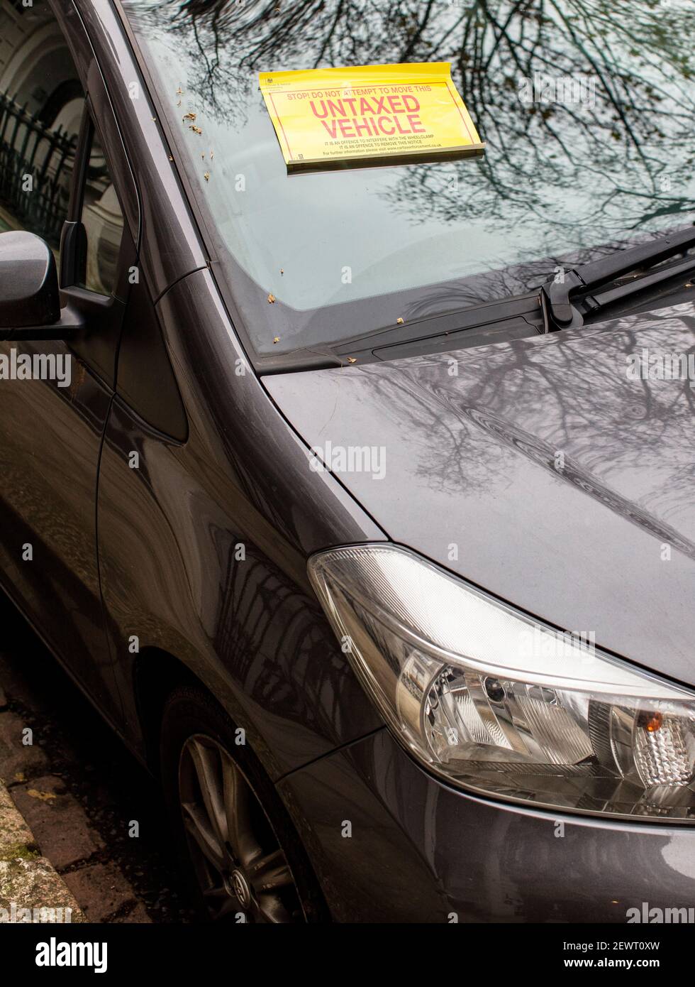 Voiture garée dans la rue London avec un avis de pénalité fixé à pare-brise indiquant l'absence de disque de taxe Banque D'Images