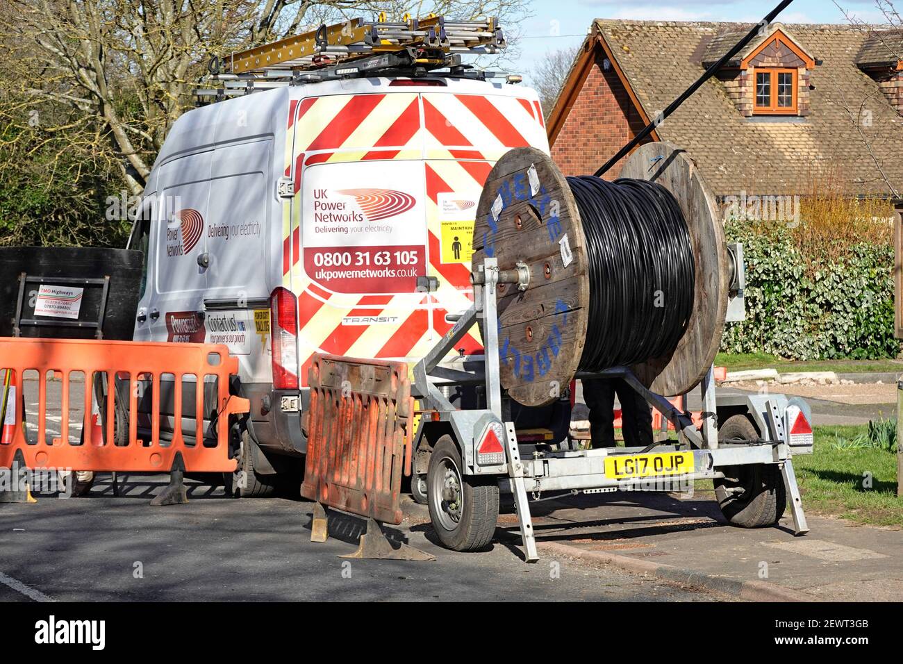 Camion commercial de distribution et remorque à tambour de câblage de UK Power Networks Remplacement des câbles aériens du réseau électrique dans le village d'Essex, Angleterre Banque D'Images