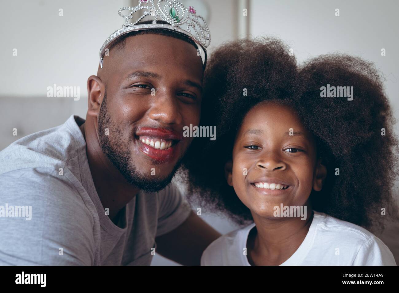 Afro-américain homme portant le tiara ayant le maquillage mis par sa fille Banque D'Images