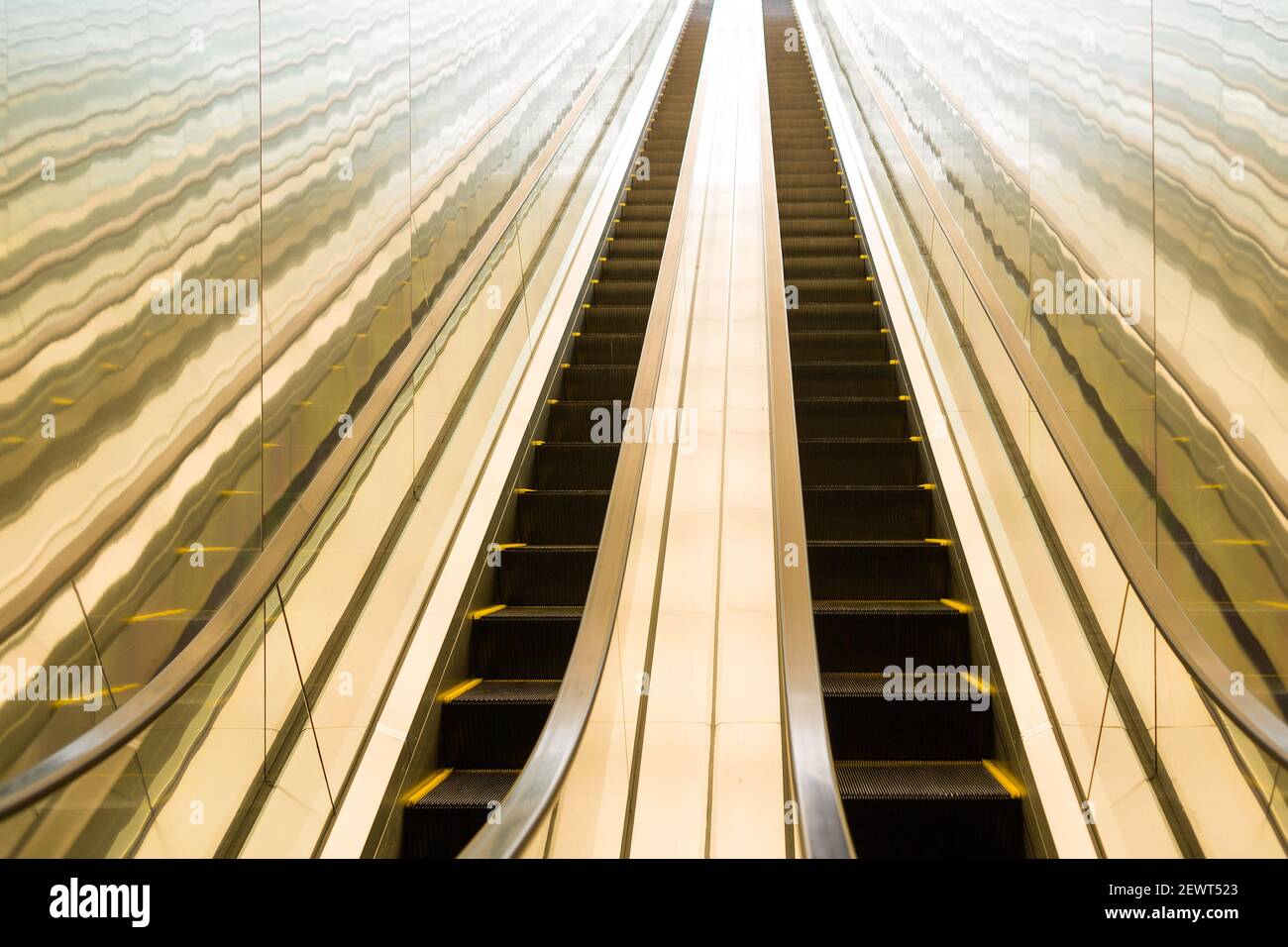 Escalier roulant long avec lumière vive à l'extrémité Banque D'Images