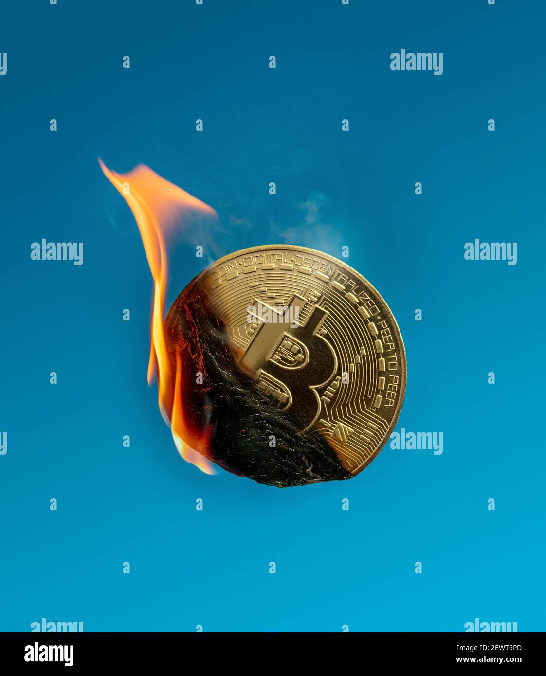 Image d'un jeton bitcoin en feu montrant des flammes et fumée représentant la chute et la consommation d'énergie Banque D'Images