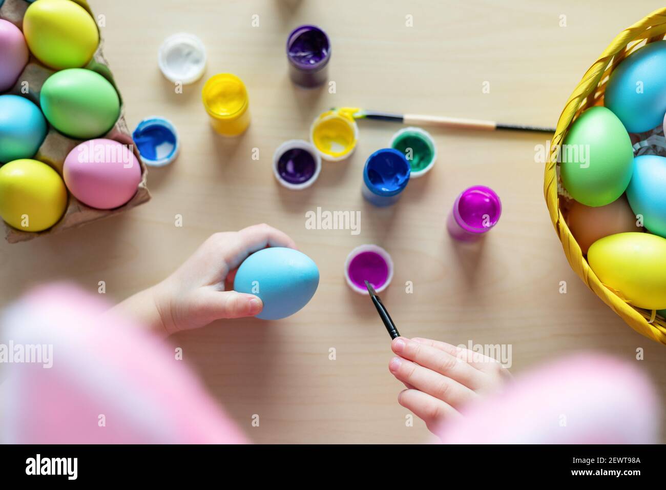 Petites mains d'enfant peignant des œufs de couleur. Fête de Pâques en famille à la maison et concept artisanal. Artisanat de Pâques à la maison. Banque D'Images