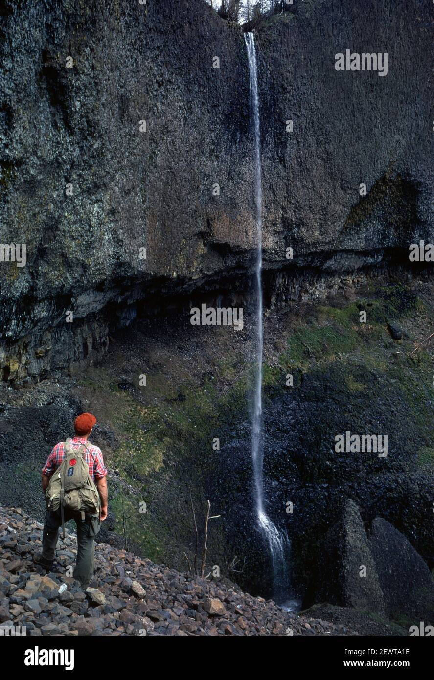 Diapositive / film d'inversion d'un homme regardant une petite cascade. Pris en avril 1961. Banque D'Images