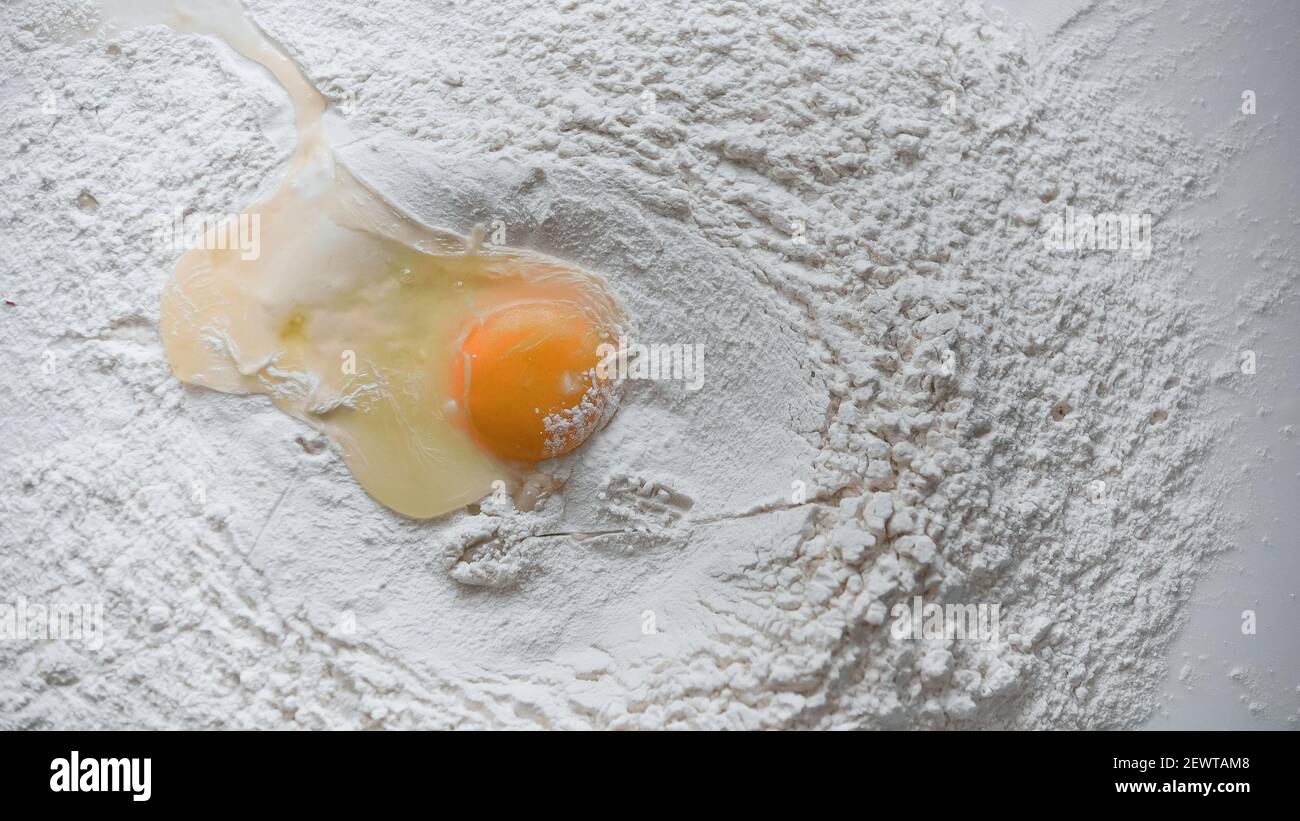 vue de dessus de l'œuf brut dans la farine blanche Banque D'Images