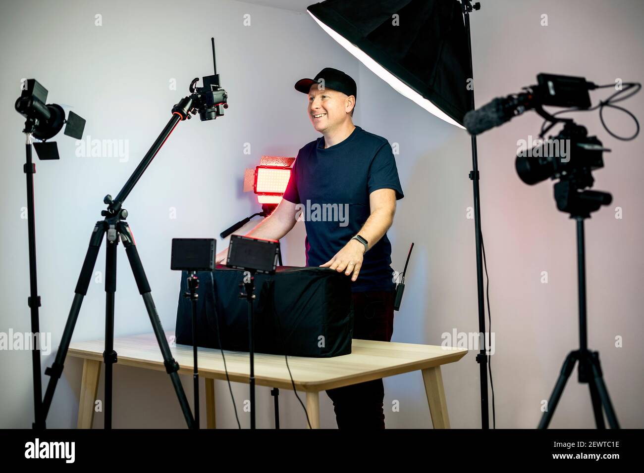 Un créateur de contenu qui se déboîte devant ses caméras et lumières dans son studio Banque D'Images