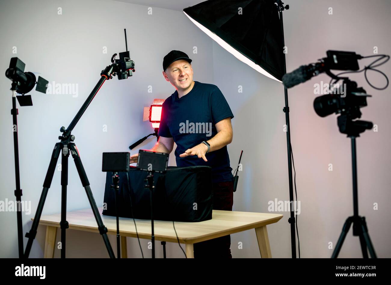 Un créateur de contenu qui se déboîte devant ses caméras et lumières dans son studio Banque D'Images