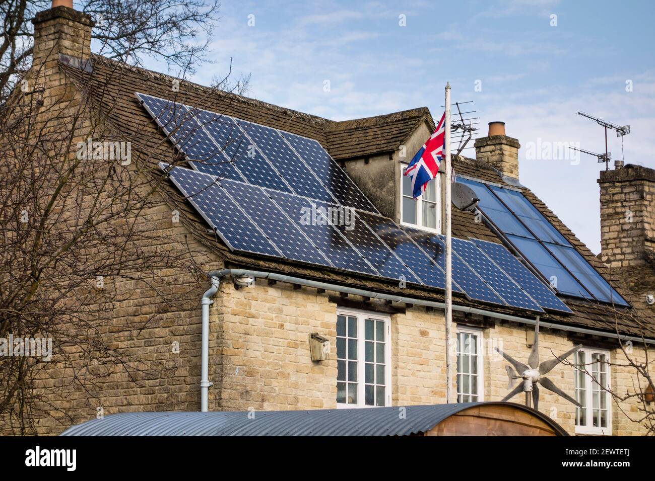 Cotswold cottage en pierre avec panneaux solaires sur le toit, Tetbury, Gloucestershire, Royaume-Uni Banque D'Images