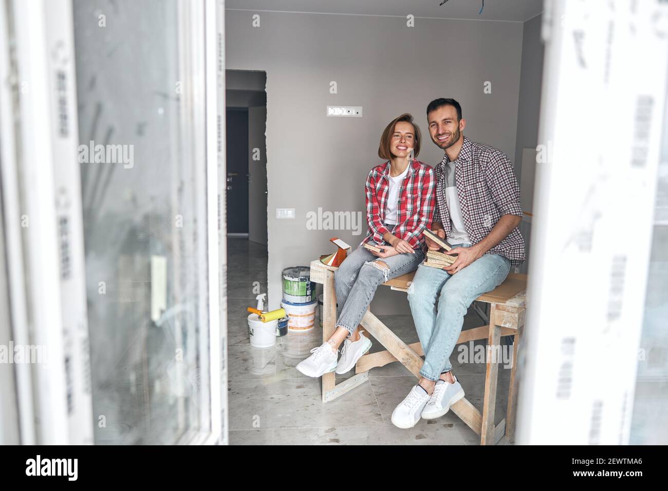 Deux travailleurs souriants portant des échantillons de panneaux de fibres de couleur Banque D'Images