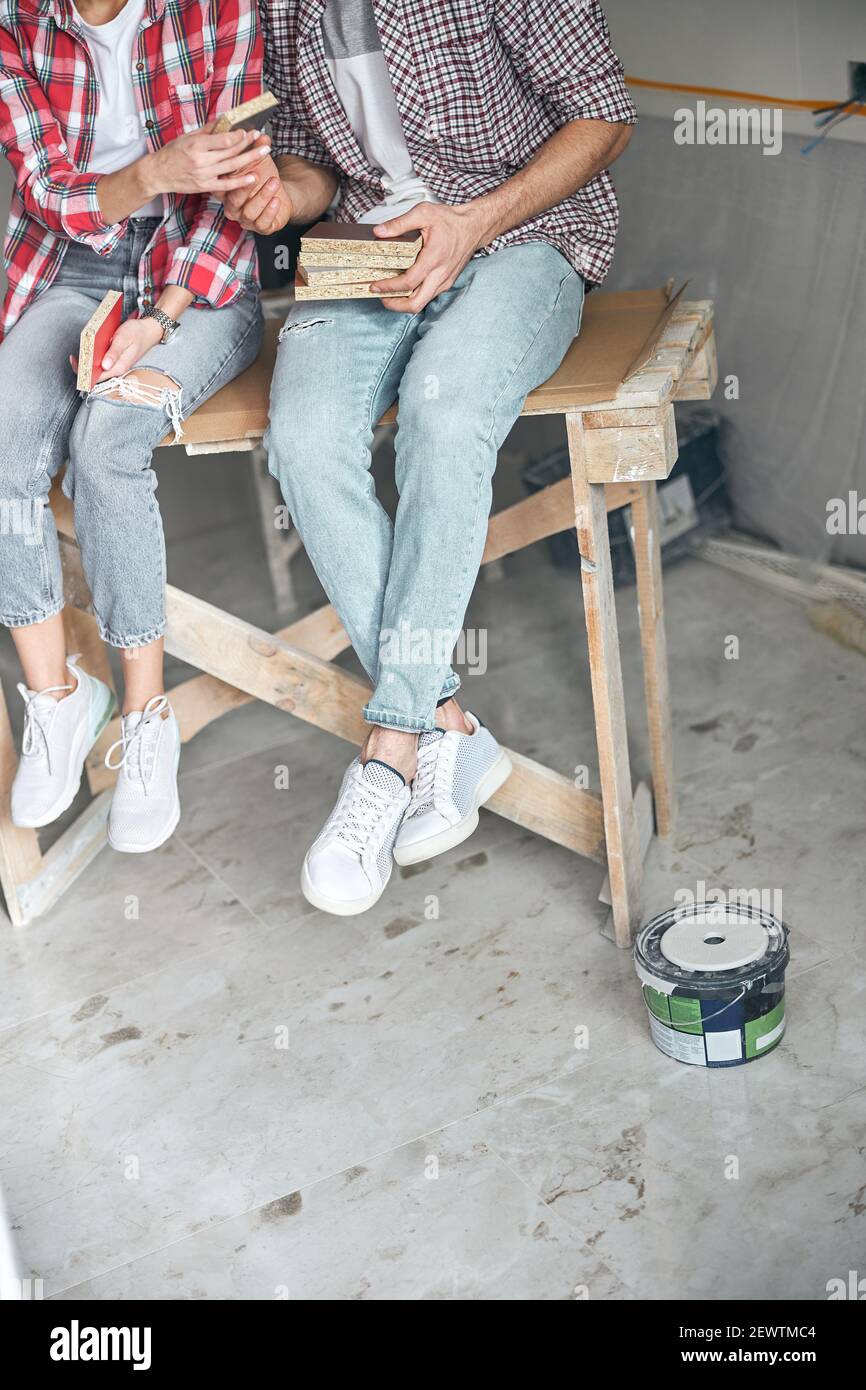 Un employé qui présente des échantillons de panneaux de fibres de couleur à sa collègue féminine Banque D'Images