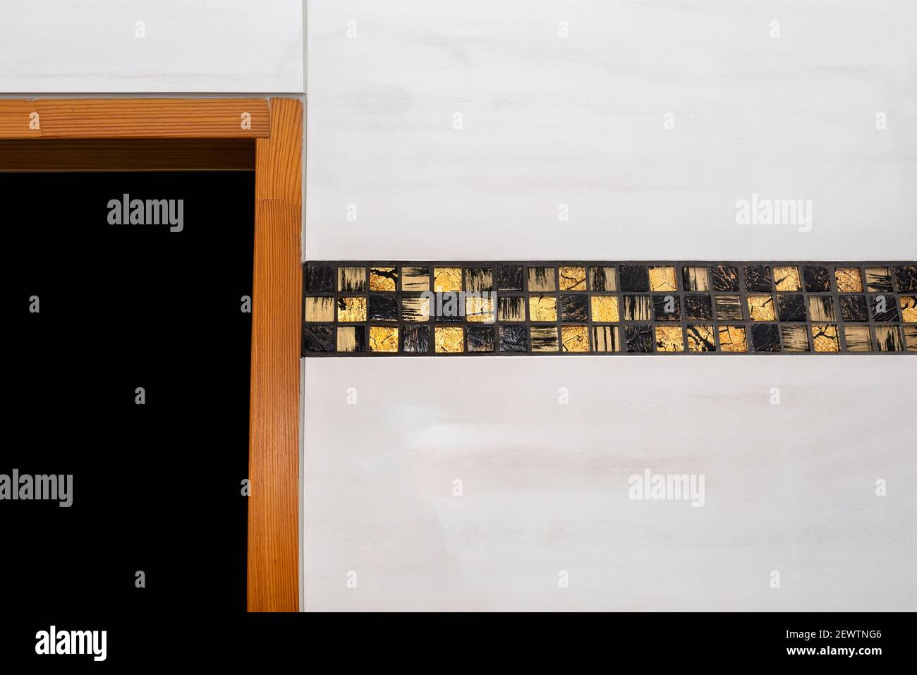 La chambre de la maison est bordée de carreaux de céramique classique avec une mosaïque dorée, cadre de porte en bois visible. Banque D'Images