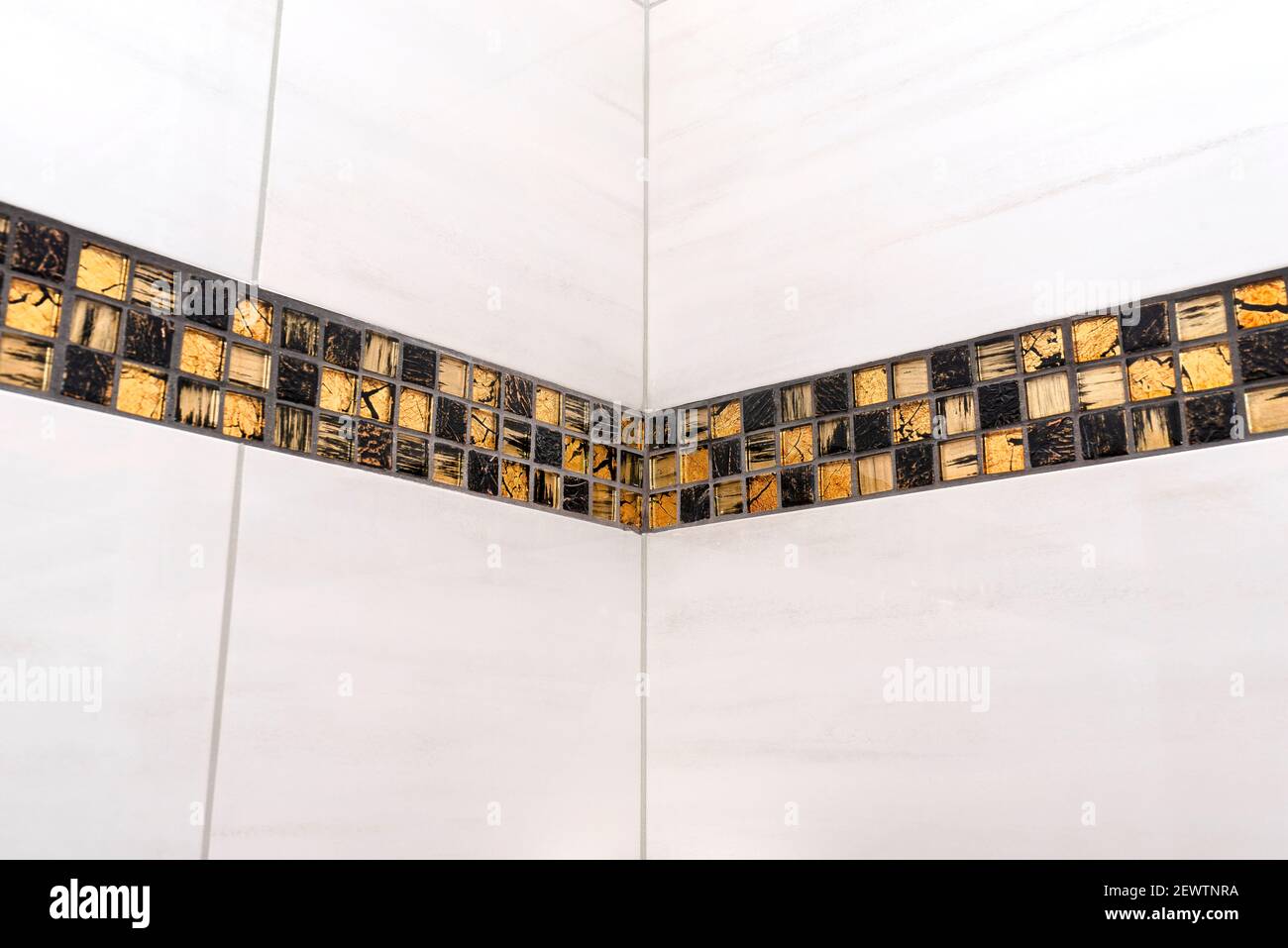 La chambre de la maison est bordée de carreaux de céramique classique avec une mosaïque dorée, les carreaux se rencontrent dans le coin de la chambre. Banque D'Images