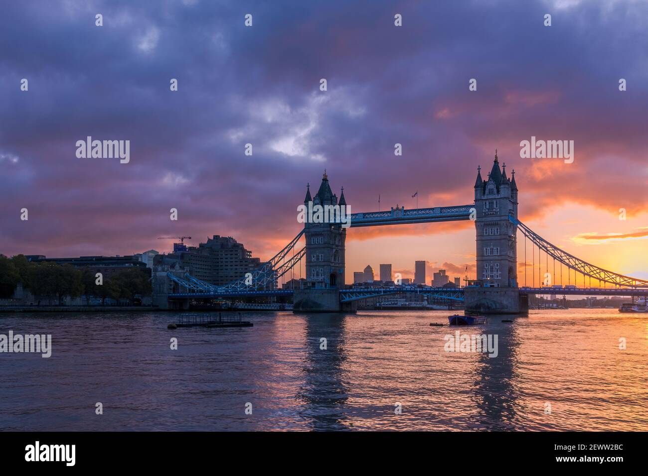 Le Tower Bridge de Londres illuminé par un lever de soleil enflammé, avec Canary Wharf en arrière-plan Banque D'Images