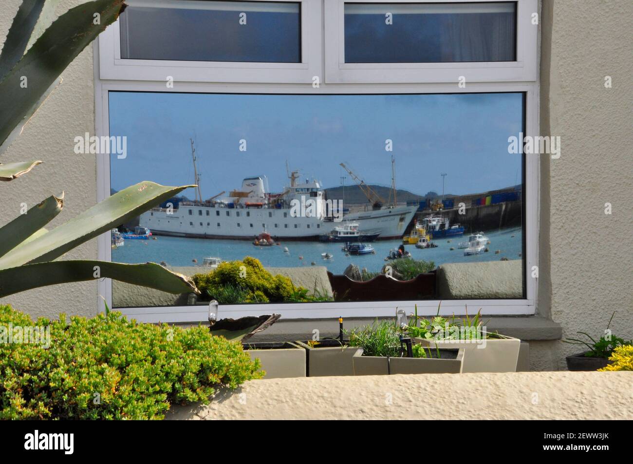 Sciillonian 3 reflète dans la fenêtre d'un cottage sur le Strand à Hugh Town, St Mary, Îles Scilly. Banque D'Images