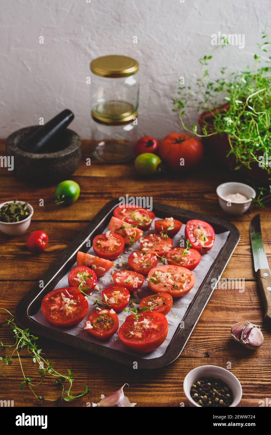 Émincé de tomates avec thym et ail sur plat à cuire prêt Pour cuisiner Banque D'Images