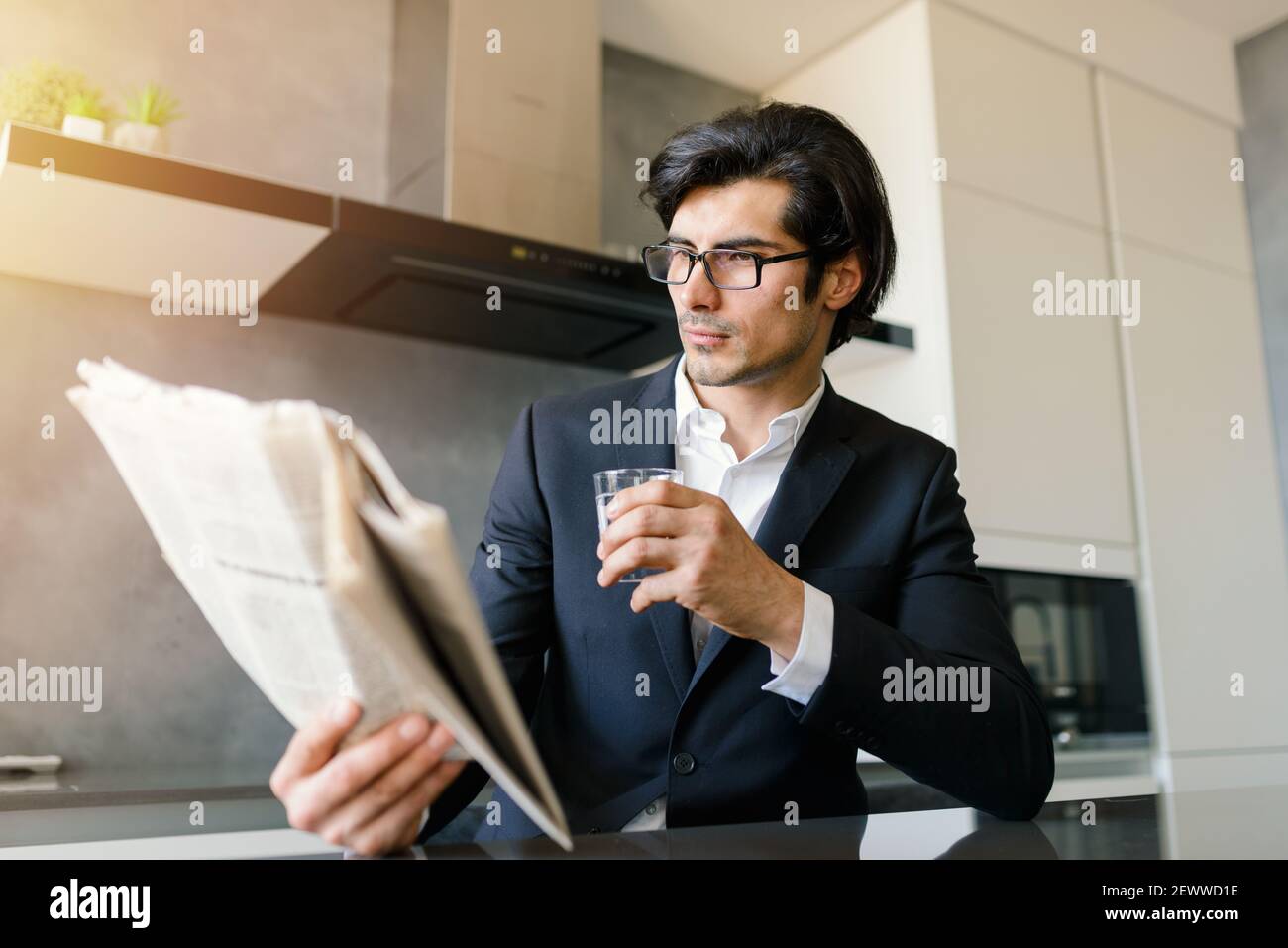 Un homme d'affaires a lu les nouvelles d'un journal tout en buvant un café à la maison Banque D'Images