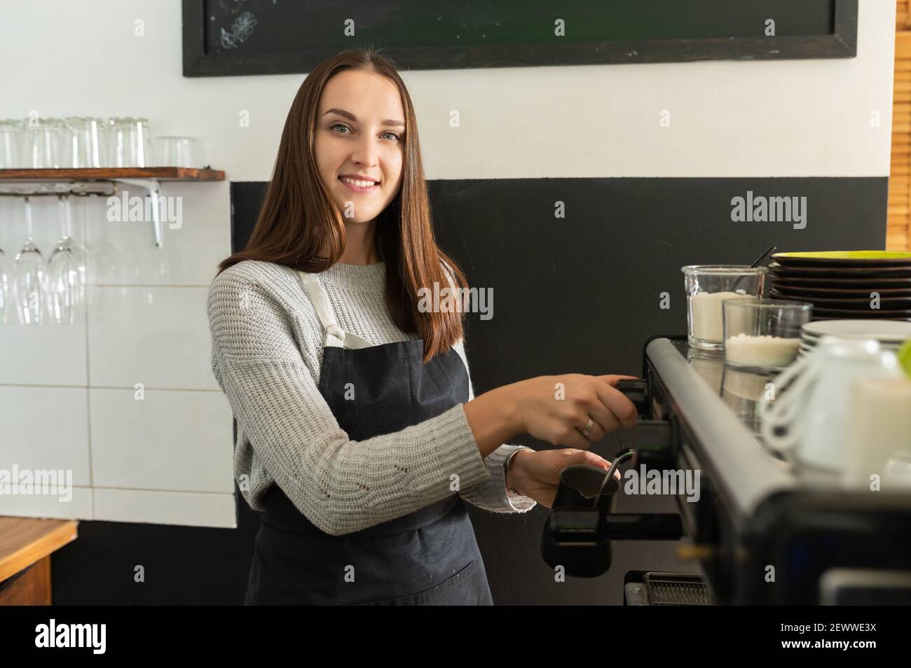 Femme Barista portant un tablier préparant du café dans un café, préparation professionnelle du café. Propriétaire d'une petite entreprise, serveuse Banque D'Images