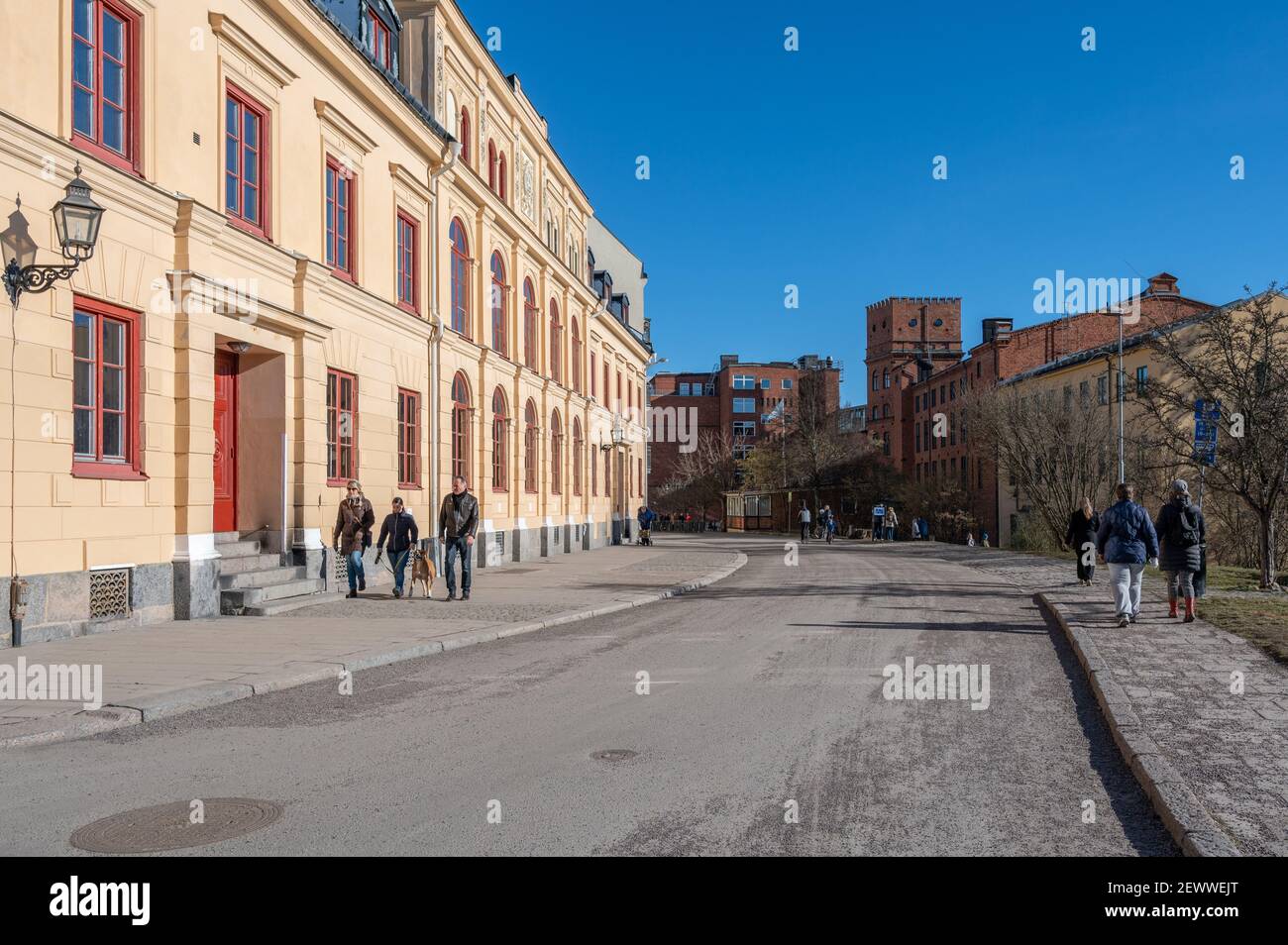 Les gens se promènent devant Arbis au début du printemps à Norrköping, en Suède. Le campus Norrkoping de Linkoping University est visible en arrière-plan. Banque D'Images
