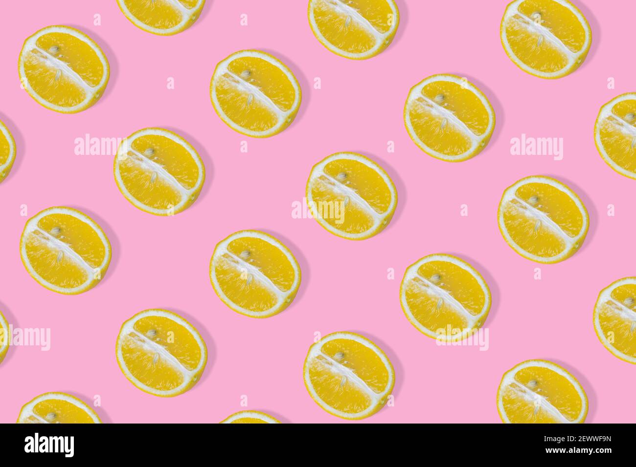 Motif été tendance avec une tranche de citron jaune sur fond rose vif. Modèle alimentaire. Concept d'été minimal. Texture des aliments à plat Banque D'Images