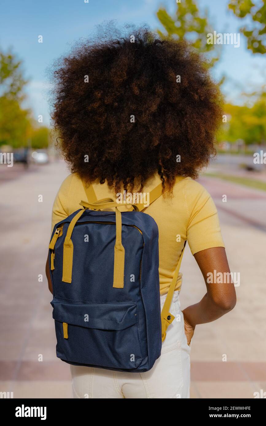 Vue arrière femme noire avec cheveux afro avec un sac à dos sur son dos Banque D'Images