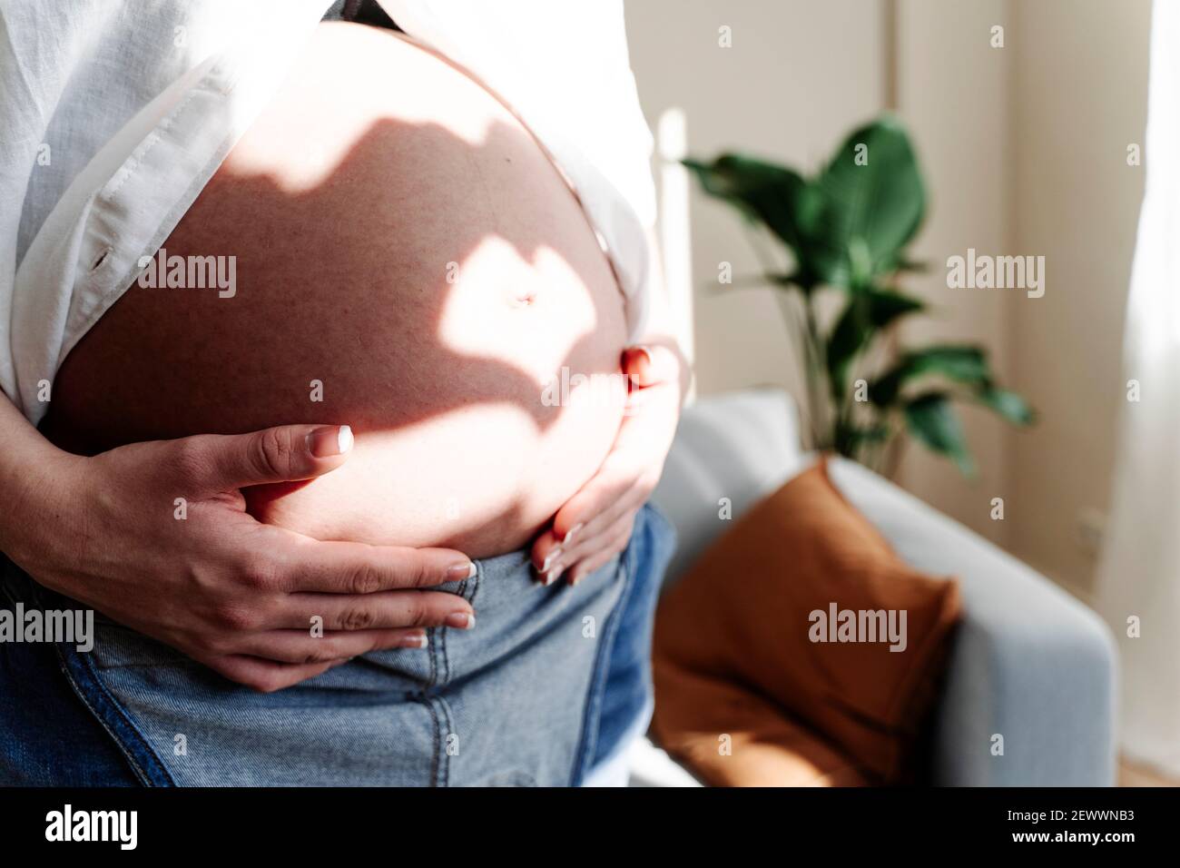 Récolte femme enceinte touchant le ventre à la maison Banque D'Images