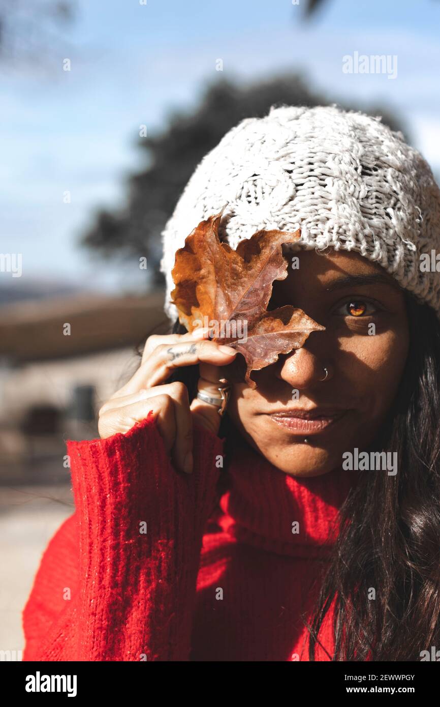 Une belle femme tenant une feuille en automne avec chapeau d'hiver Photo  Stock - Alamy
