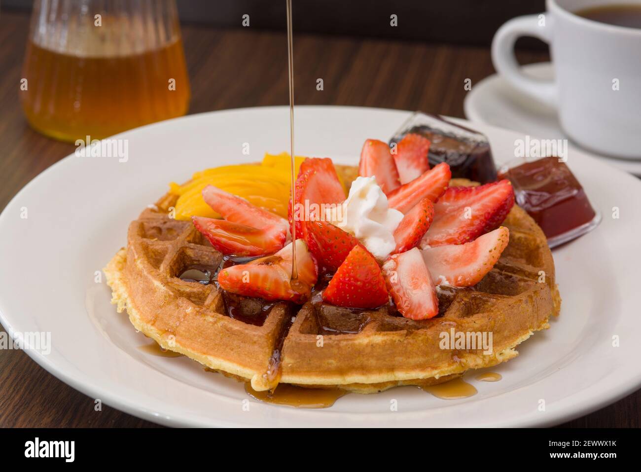 Gaufre belge avec du miel qui coule dessus Banque D'Images