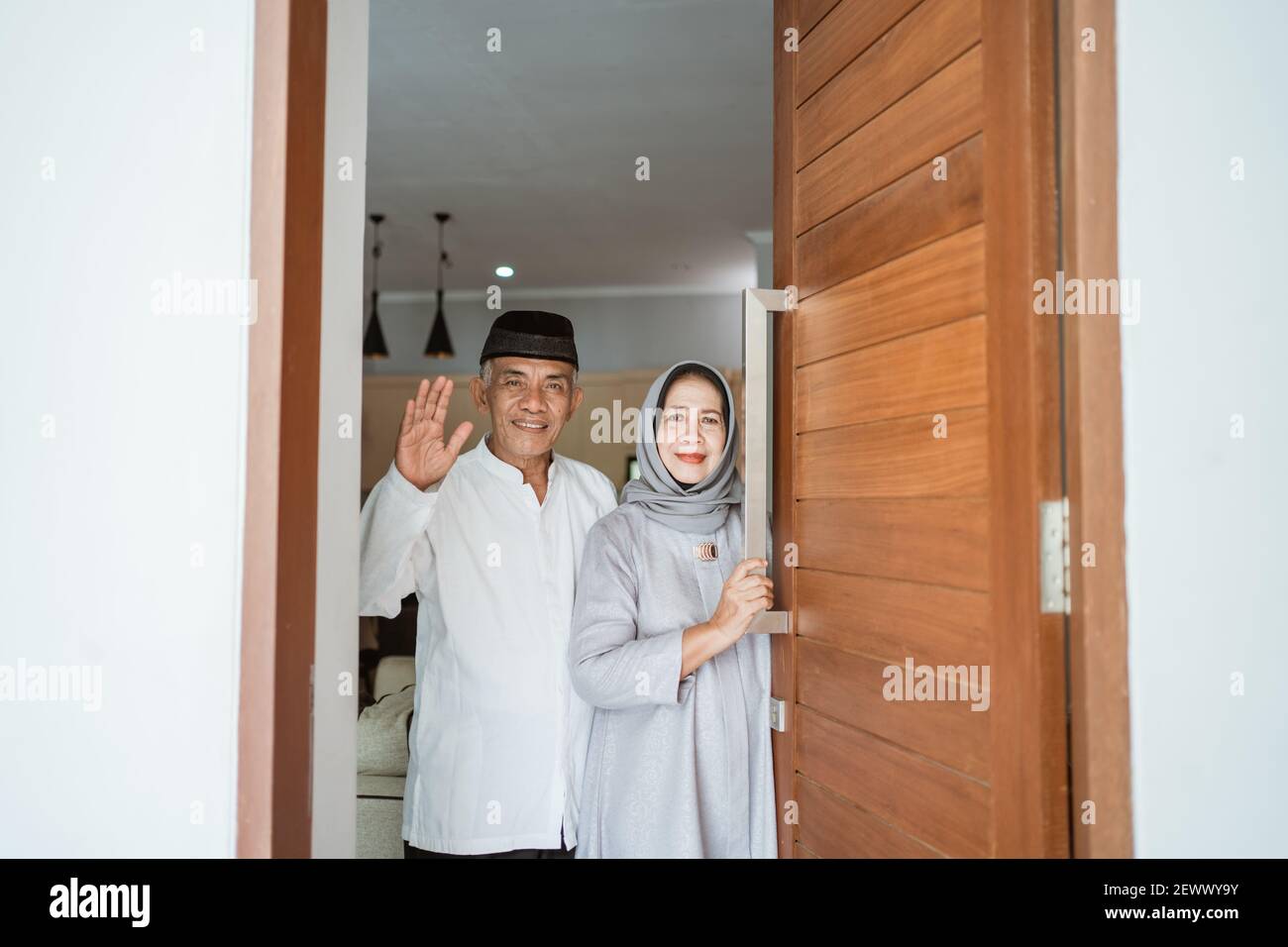 portrait d'un couple asiatique musulman debout devant la porte d'entrée attendre que la famille vienne Banque D'Images