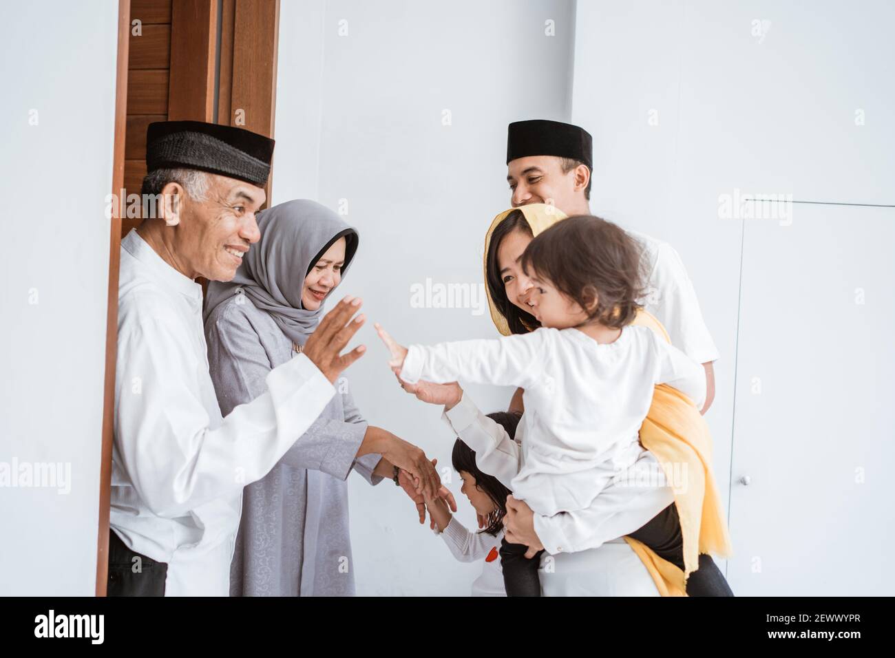 Joyeux couple asiatique musulman âgé qui rencontre les enfants et les grands enfants a deux pas de l'hôtel lors de la célébration de l'eid moubarak Banque D'Images
