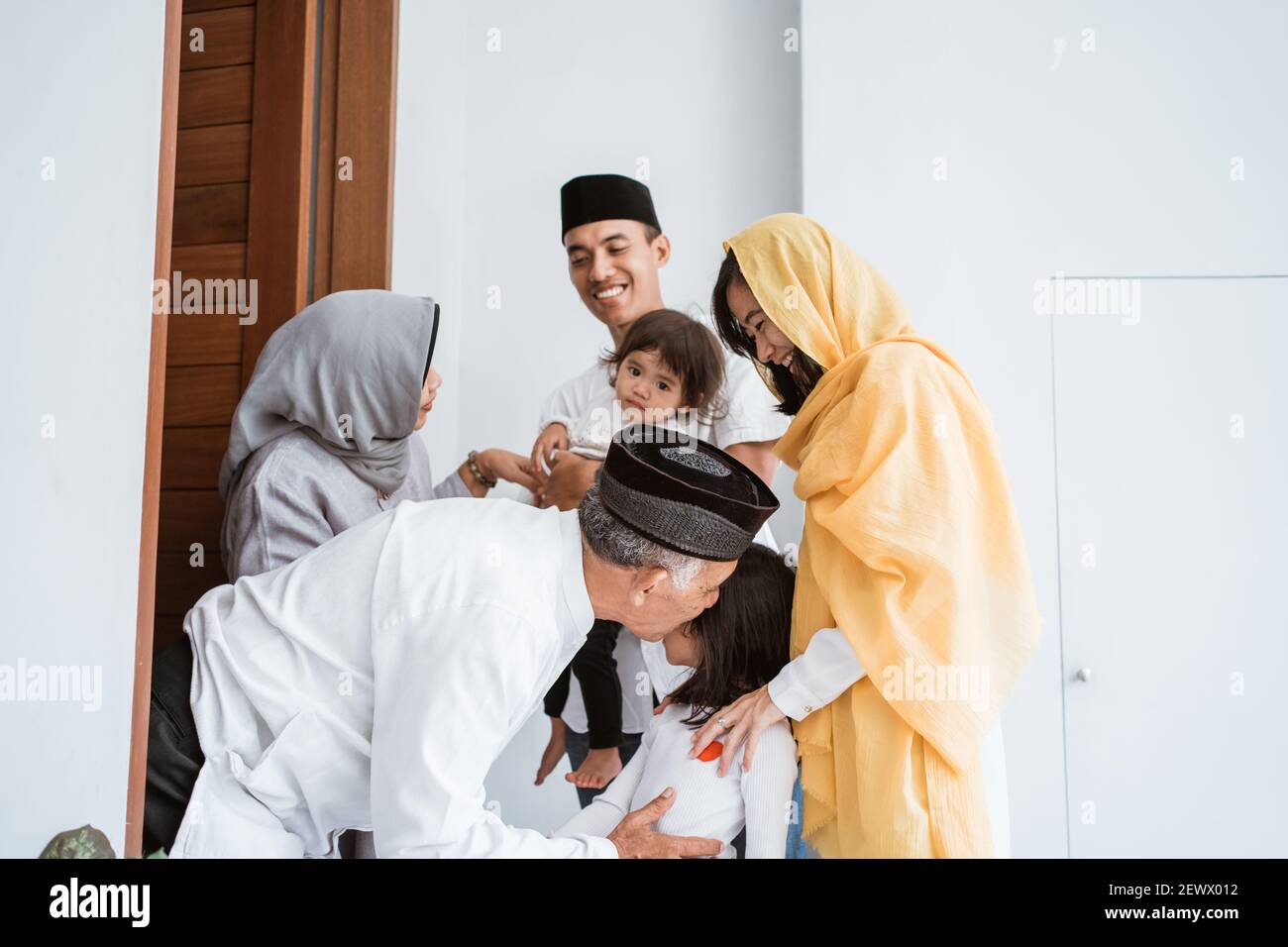 Joyeux couple asiatique musulman âgé qui rencontre les enfants et les grands enfants a deux pas de l'hôtel lors de la célébration de l'eid moubarak Banque D'Images