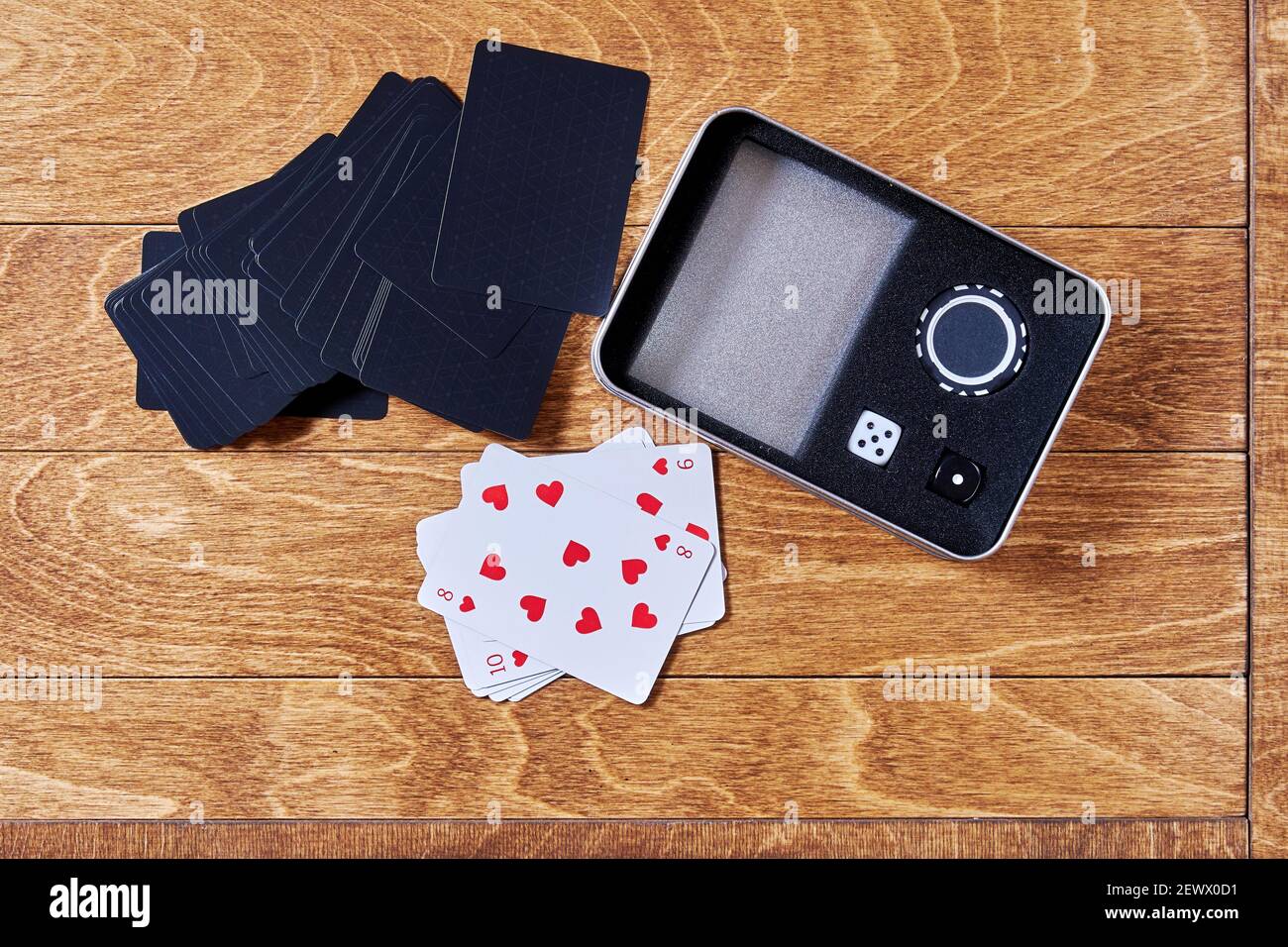 Caisse de poker avec cartes à jouer, dés et jetons sur la surface en bois. Activités de loisirs et jeux d'argent Banque D'Images