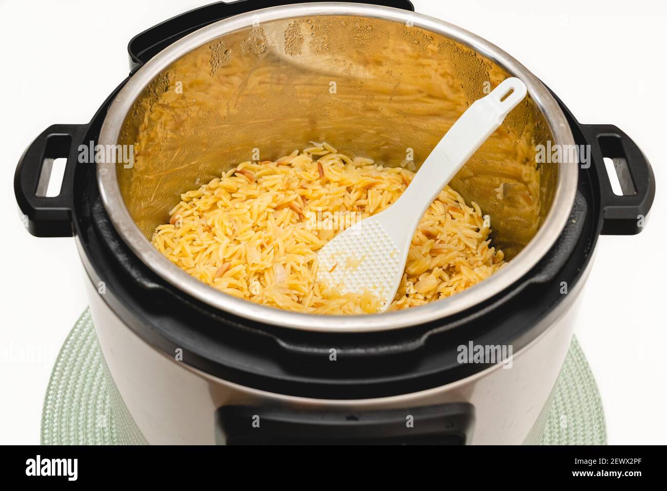Pâtes cuites dans un pot instantané. Délicieux orzo pâtes gros plan dans un pot sur fond blanc avec espace de copie Banque D'Images