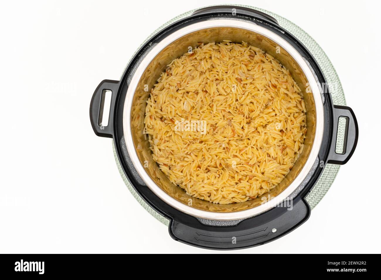 Pâtes cuites dans un pot instantané. Délicieux orzo pâtes gros plan dans un pot sur fond blanc avec un espace de copie directement d'en haut Banque D'Images
