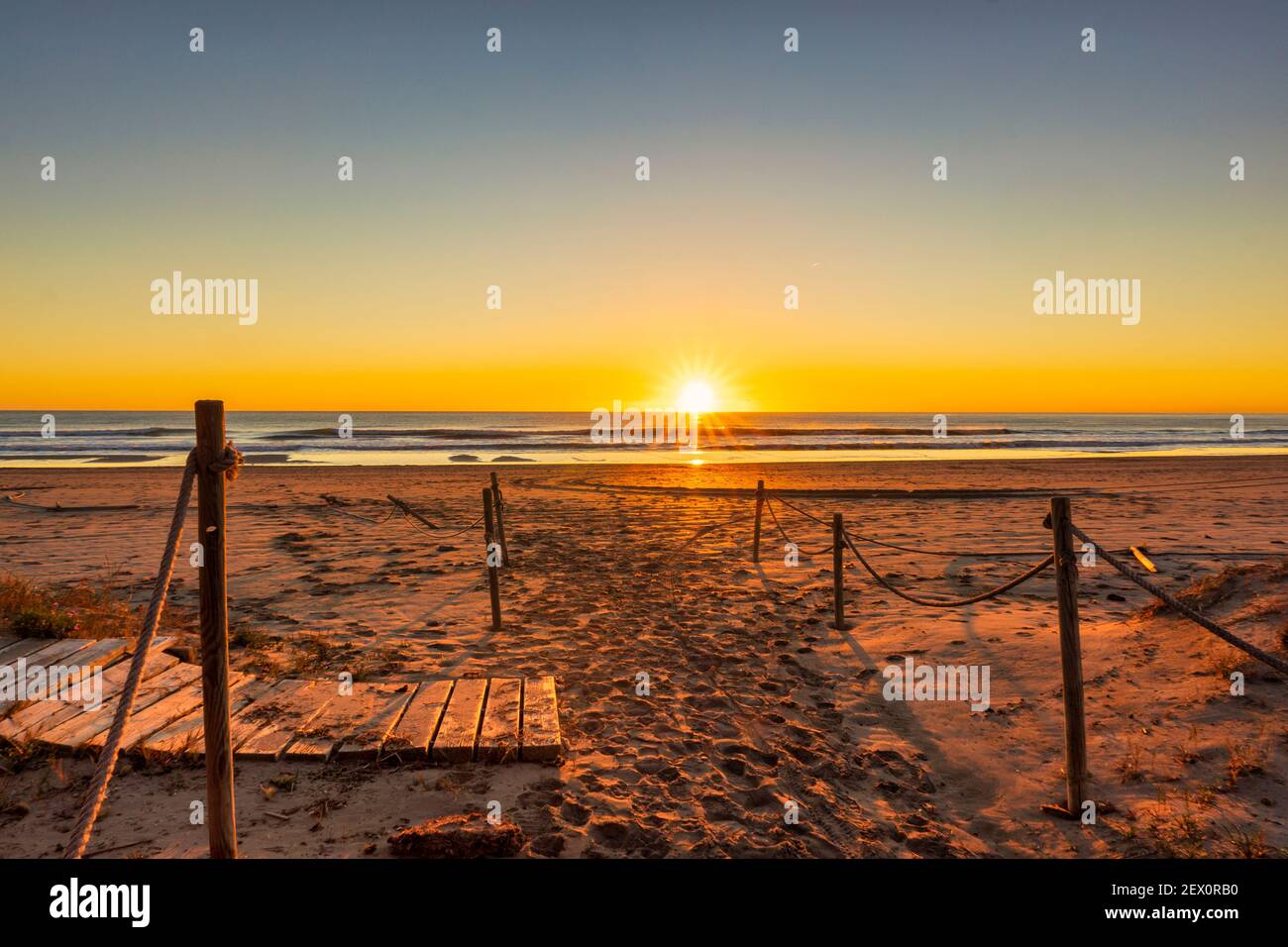 La plage pendant un beau et calme lever du soleil Banque D'Images