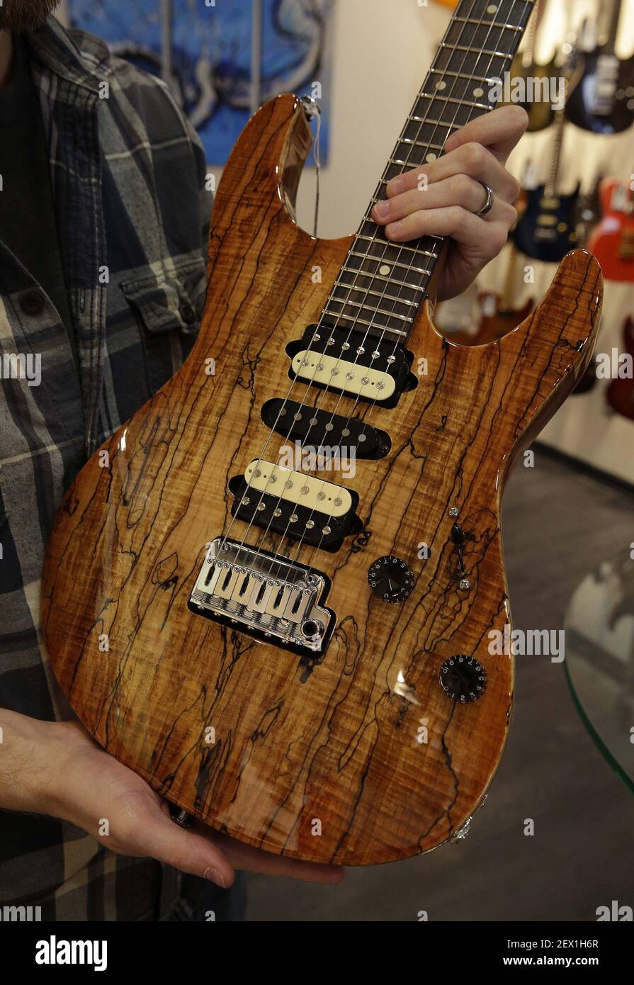 Noah Saydel, responsable marketing de la guitare distinctive, détient une guitare  Suhr avec un haut en érable spalted et une belle finition le 28 janvier  2015 à Milwaukee, Wisconsin. Certaines de leurs