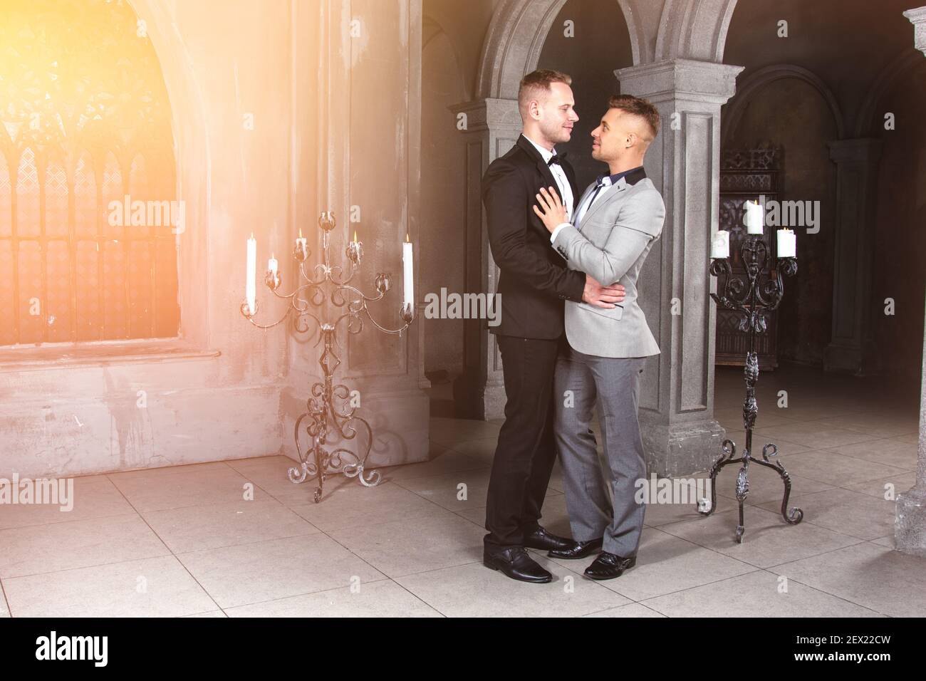 Jeune heureux gay couple se marient dans l'église. Amour et romance. Des hommes séduits en costume. Banque D'Images